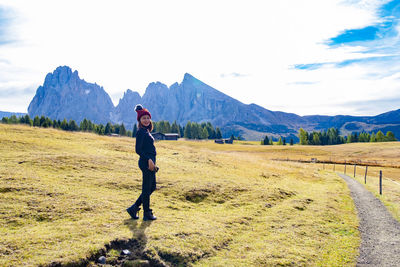 Full length of woman standing on field against sky