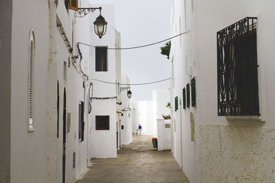 Alley amidst white buildings