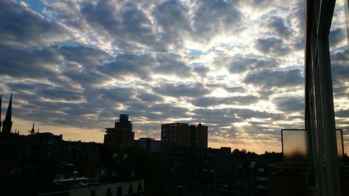 Buildings against cloudy sky at sunset