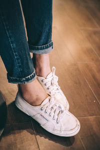 Low section of woman standing on hardwood floor