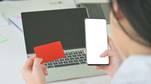 Midsection of woman using mobile phone on table