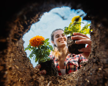 Young woman holding flowers. gardening. view from below.