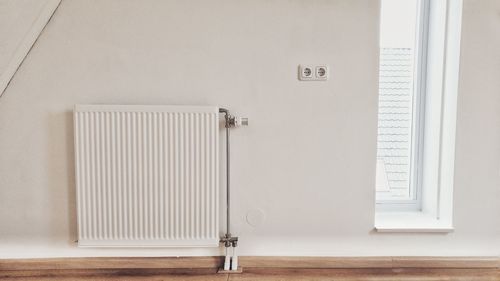 Radiator on white wall at home