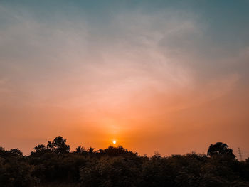 Low angle view of silhouette trees against romantic sky