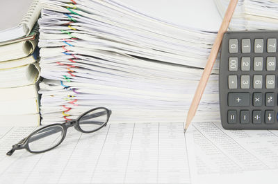 Close-up of eyeglasses and calculator on financial documents