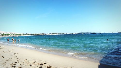 Scenic view of beach against clear blue sky