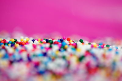 Close-up of colorful sprinkles against pink background