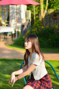 Portrait of young woman standing on field