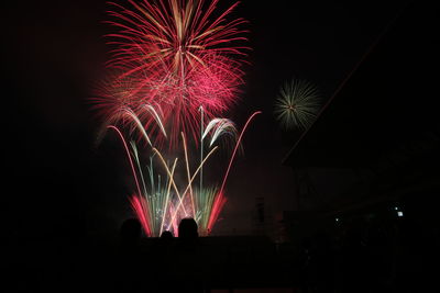 Low angle view of firework display at night