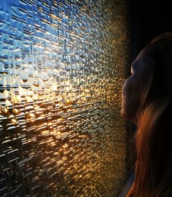 Full length portrait of woman looking at sea during sunset