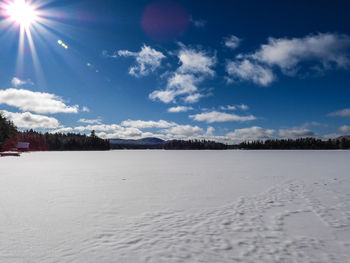 Scenic view of snow covered field against sky