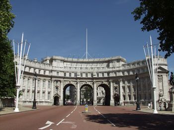 Road leading to built structure against sky