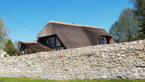 Low angle view of old building against clear blue sky