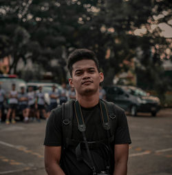 Portrait of young man standing on street in city