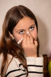 Teenage girl dealing with her first facial makeup tricks