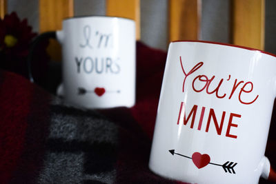 Close-up of mug with texts on blanket