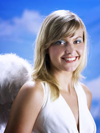 Portrait of beautiful young woman wearing angel wings