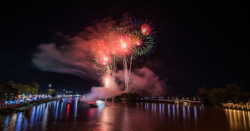 Firework display over river at night