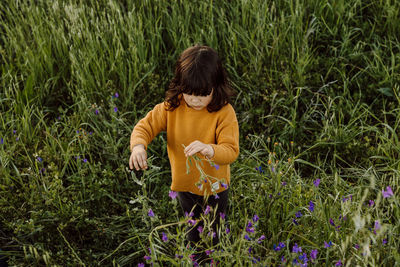 Rear view of woman standing amidst plants