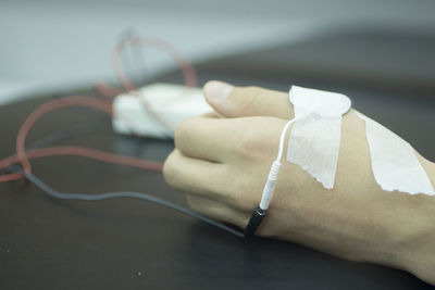 Cropped hand of patient with medical equipment in hospital