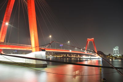 Illuminated suspension bridge over river at night