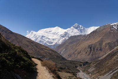 Scenic view of snowcapped mountains against clear blue sky