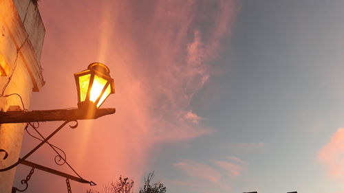 Low angle view of road sign against sky during sunset