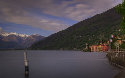 Scenic view of lake by buildings against sky