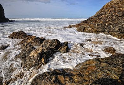 Scenic view of rocks in sea against sky