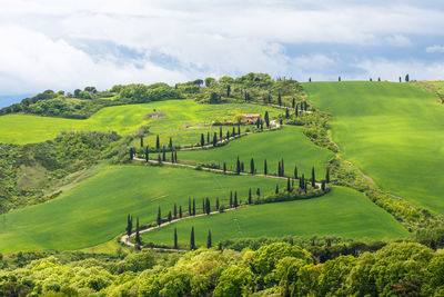 Scenic view of green mountains against cloudy sky