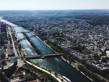 High angle view of illuminated city by river against sky