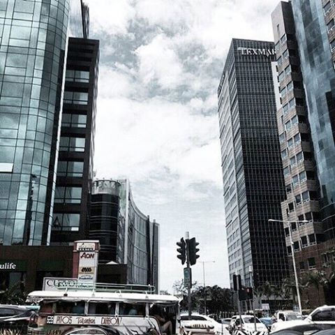 building exterior, architecture, built structure, city, skyscraper, building, car, sky, office building, modern, tall - high, land vehicle, transportation, low angle view, mode of transport, street, residential building, city life, tower, cloud - sky