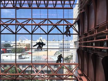 Man in city against sky seen through window
