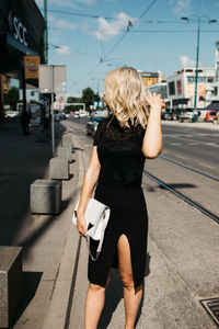 Fashionable woman standing against buildings in city