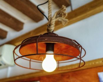 Low angle view of illuminated lamp hanging on ceiling