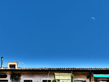 Low angle view of buildings against clear blue sky