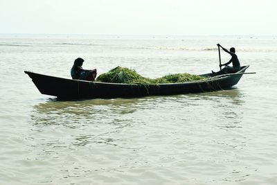 Man in boat on sea against sky