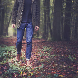 Low section of man standing in forest