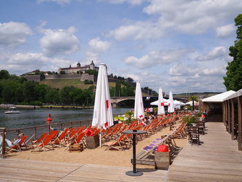 Chairs and table by trees against sky