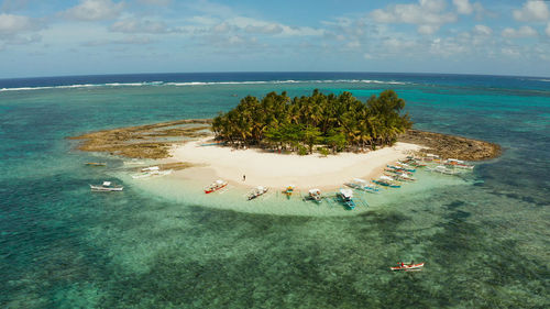 Tropical island with sand beach, palm trees by atoll. guyam island, philippines, siargao. 