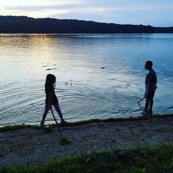 Full length of man fishing at lakeshore
