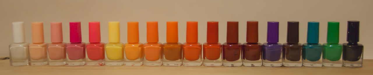 Panoramic shot of various nail polish bottles on table