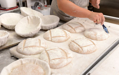 Close-up of hand making bread at counter in kitchen