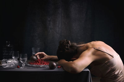 Woman offering a passion fruit between crystal crockery iii