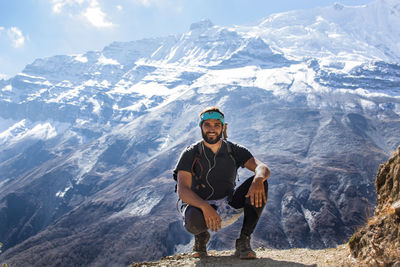 Portrait of man sitting on rock