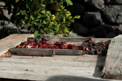 Dry red chili peppers on wooden table during sunny day