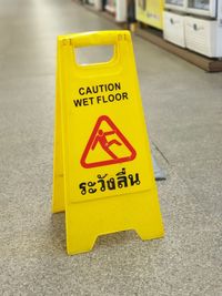 Close-up of yellow sign on road