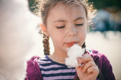 Close-up of cute girl holding cotton candy