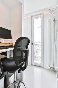 Empty chairs and table by window at home