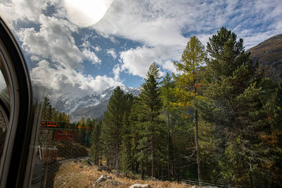 Scenic view of trees and mountains against sky